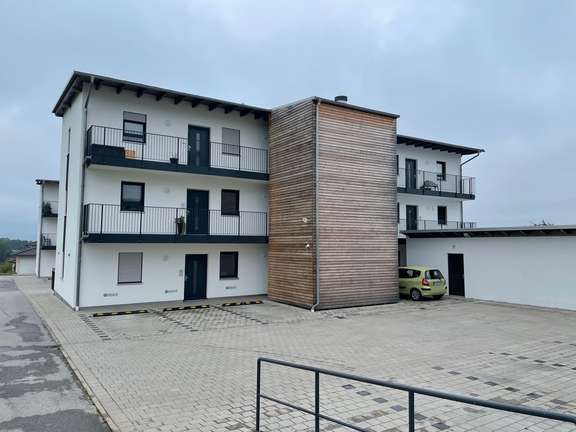 Referenzobjekt: Mehrfamilienhaus mit Balkonen und holzverkleidetem Treppenhaus