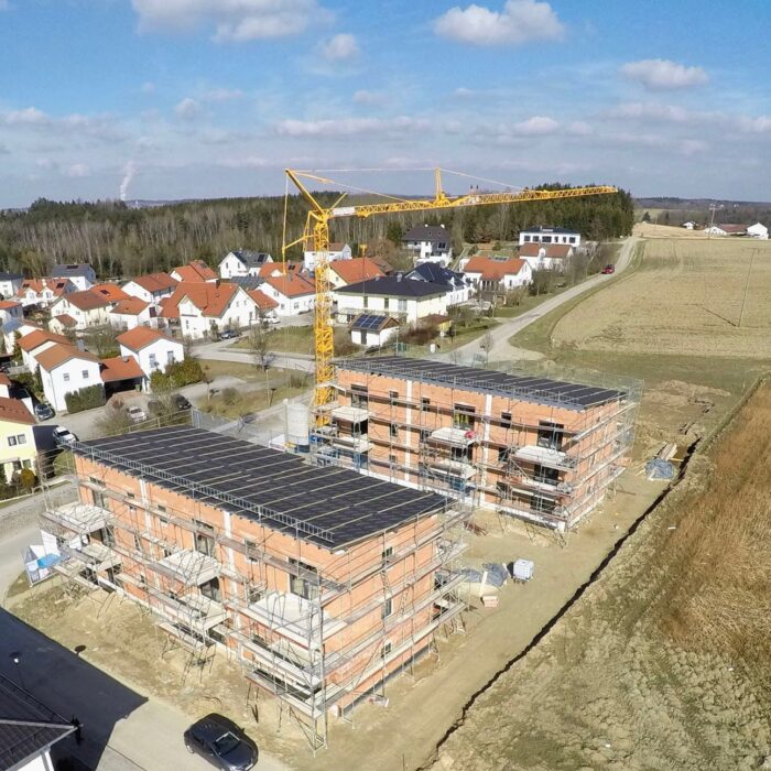 Referenzobjekt: Luftaufnahme einer Baustelle mit Rohbauten und Baukran