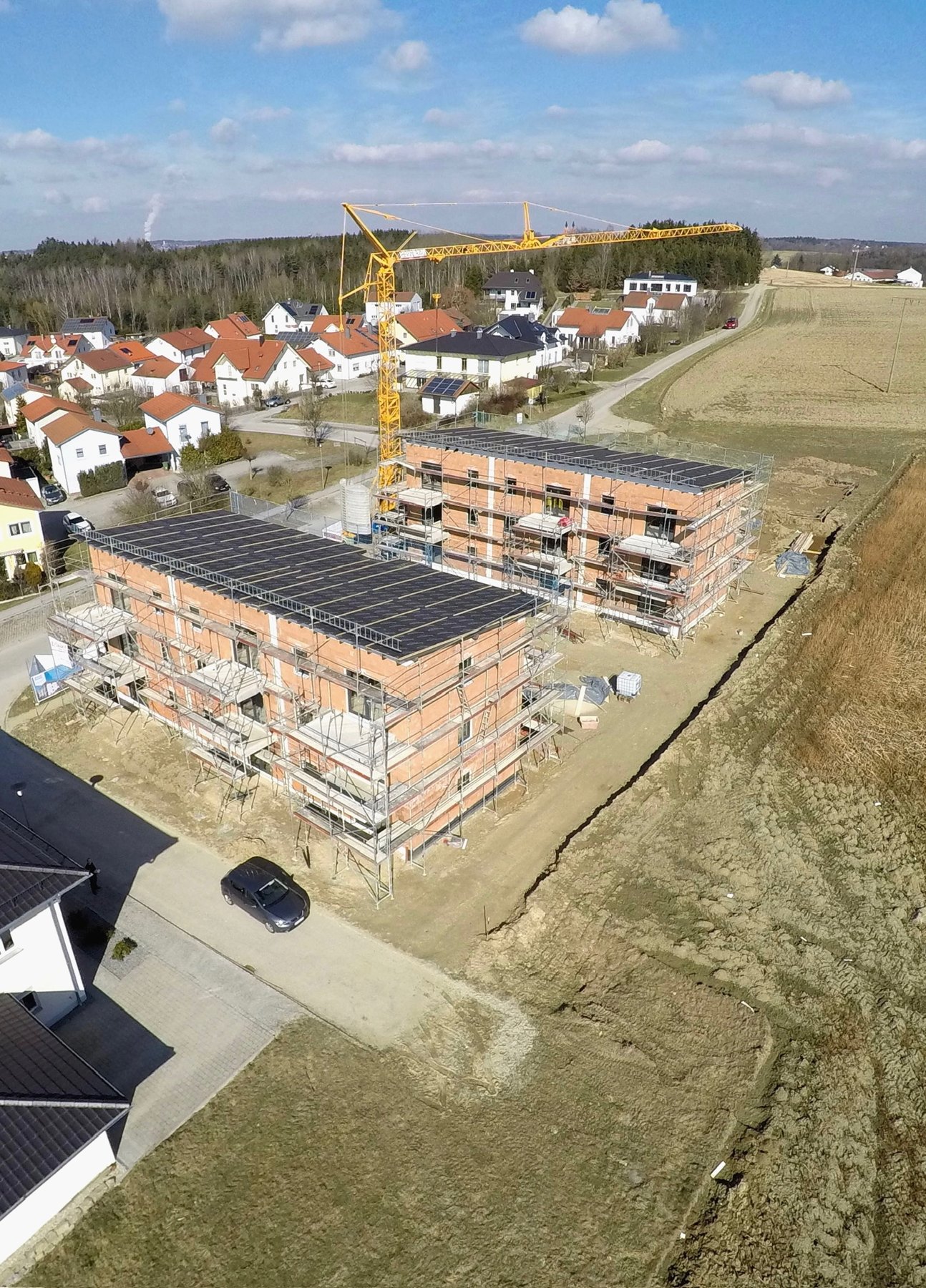 Referenzobjekt: Luftaufnahme einer Baustelle mit Rohbauten und Baukran